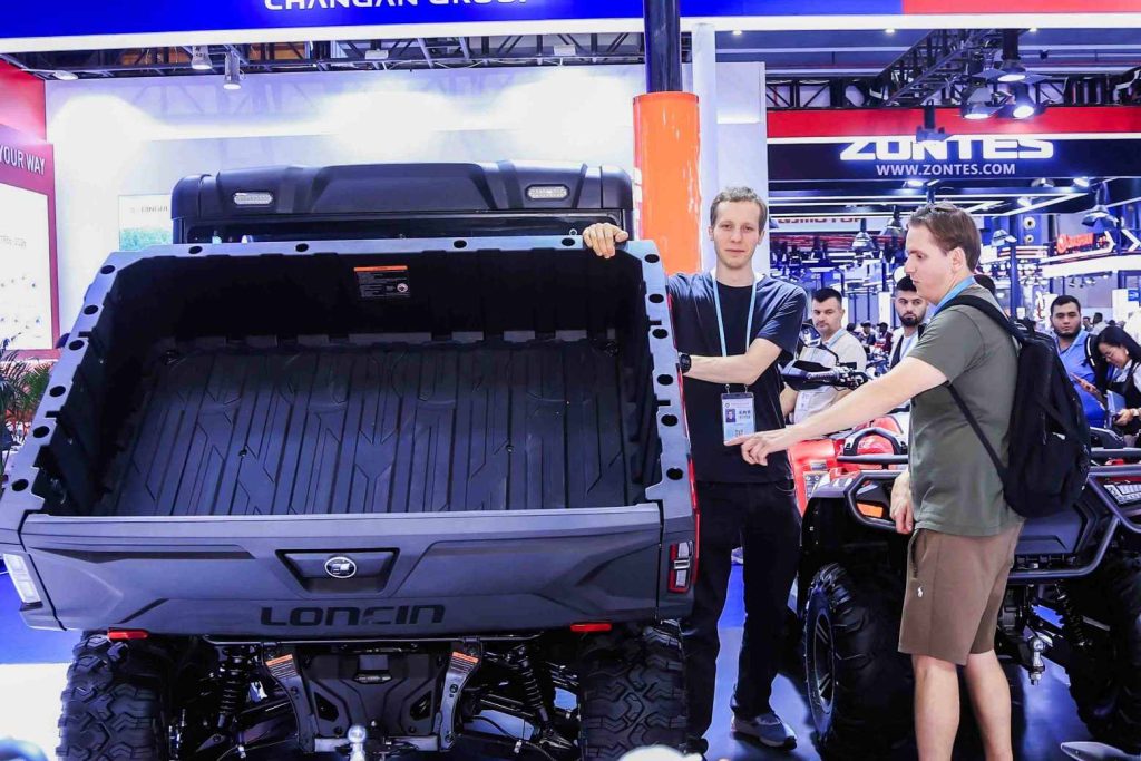 LONCIN ORV Concludes Successful Run at the 140th Canton Fair 3 Visitors inspecting the LONCIN UWOLF1000 tilting cargo bed at the Canton Fair